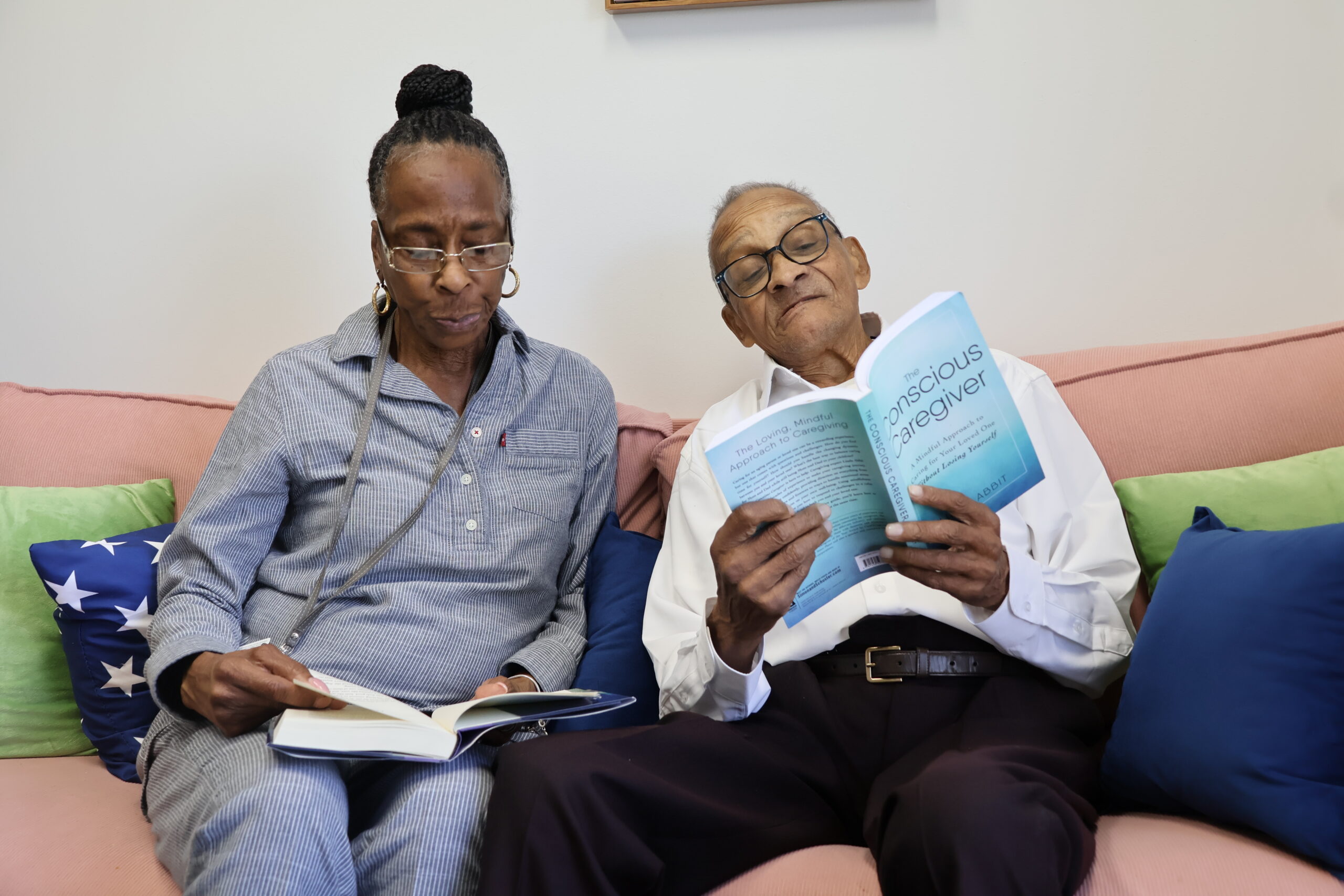 caregiver holding a senior woman's shoulder while both smile