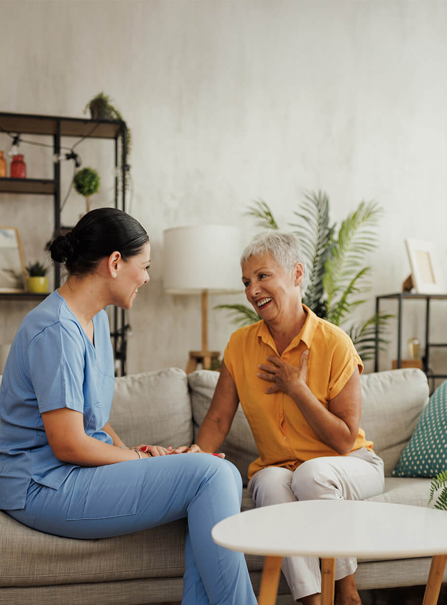 edited-caregiver-and-senior-woman-sitting-andtalking-on-a-couch